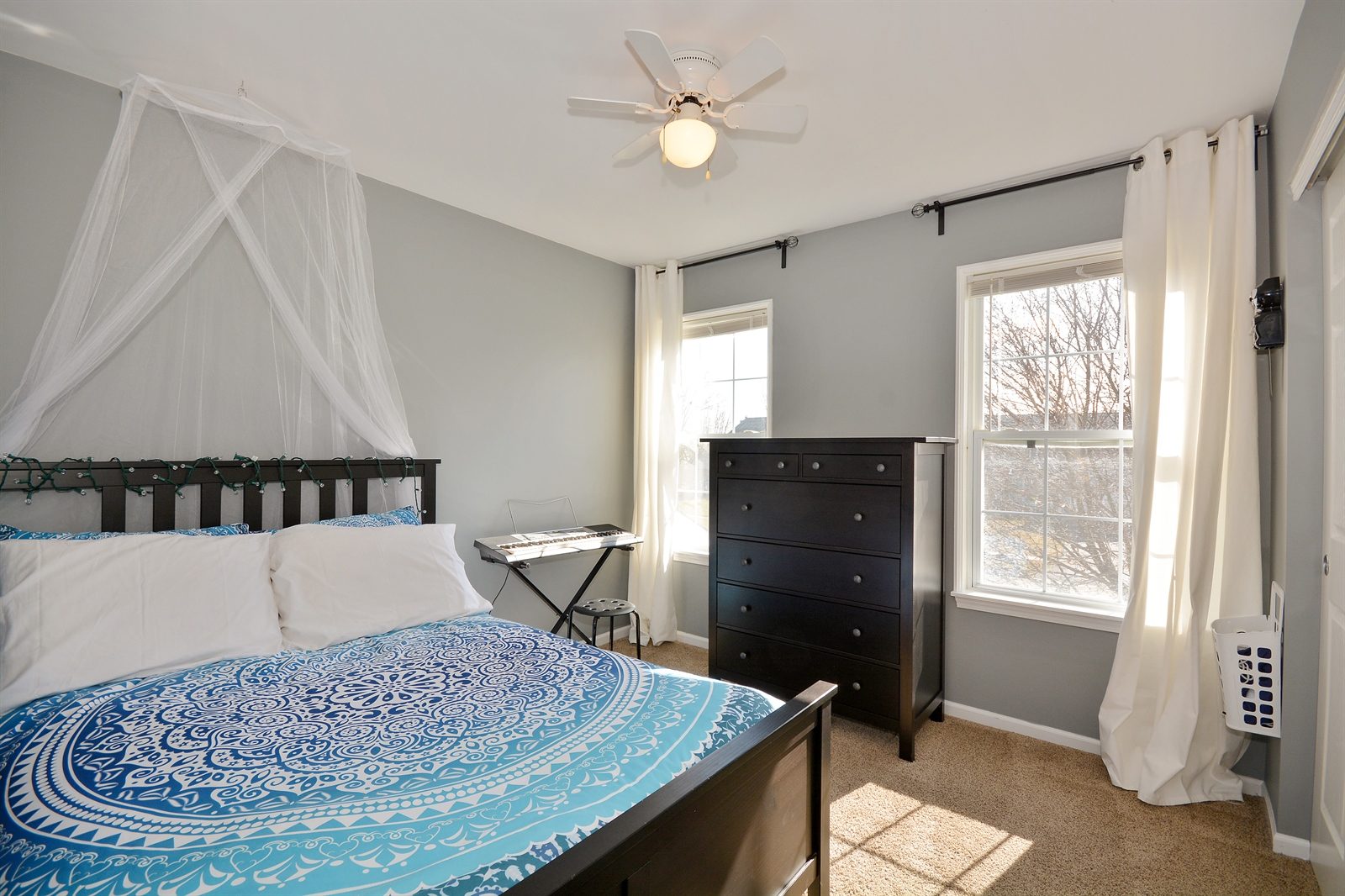 Installation of two curtain rods to hold floor-to-ceiling curtains in a bedroom